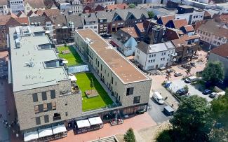 Today, the former Hertie department store in Lünen is a modern residential and commercial property with 850 m² of play and sunbathing lawn right in the middle of the roof. © GRÜN+DACH / ZinCo Bird's eye view onto a green roof with lawn in the city